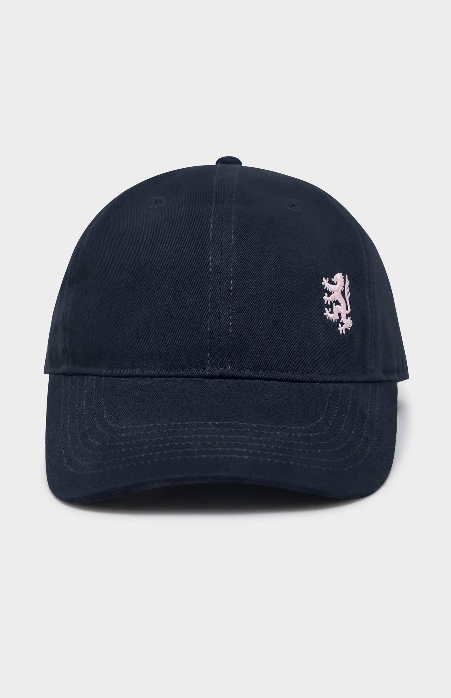Navy baseball cap with light pink lion logo embroidery on the right hand side