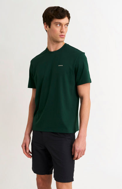 man wearing a dark green t-shirt and black shorts on a white background