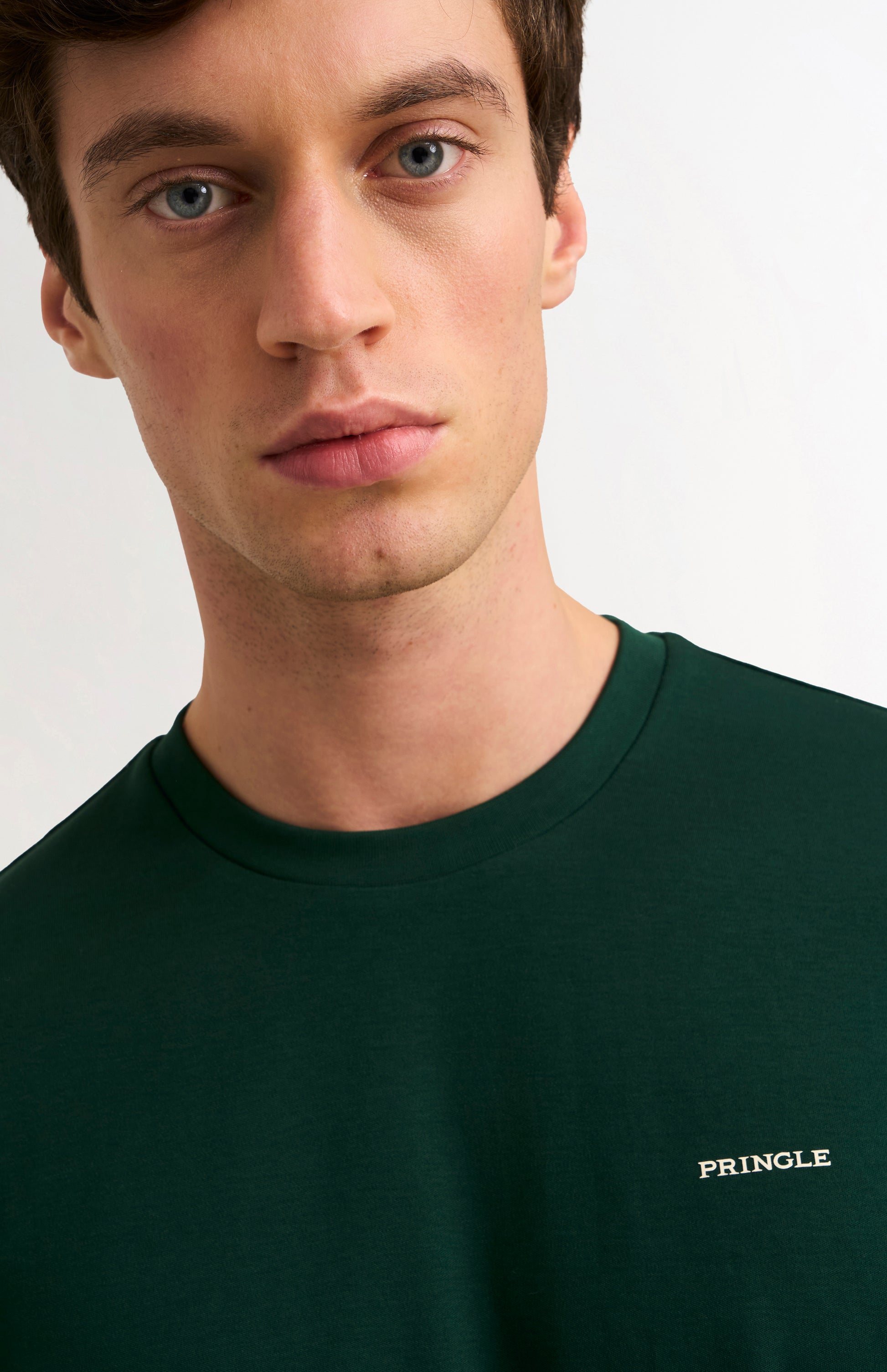 Man wearing a dark green t-shirt on a white background