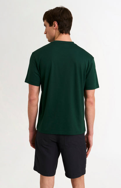 Person wearing a green t-shirt and black shorts on a white background