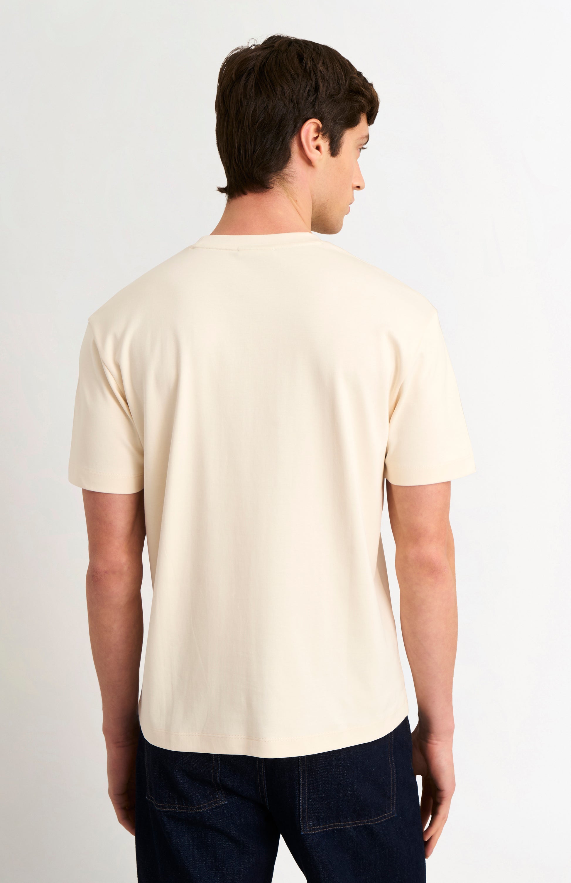 Man wearing a beige t-shirt on a white background