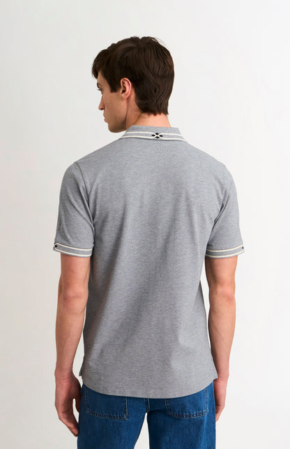 Man wearing a gray polo shirt with white trim on a plain background