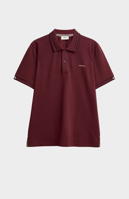 A burgundy polo shirt with black tipping details against a light grey background