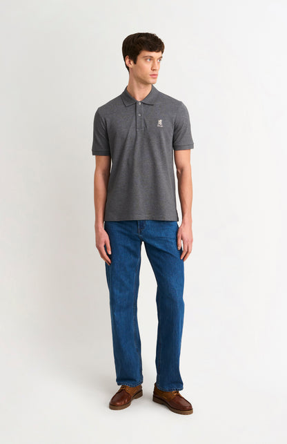 Man wearing a dark gray polo shirt and blue jeans on a white background