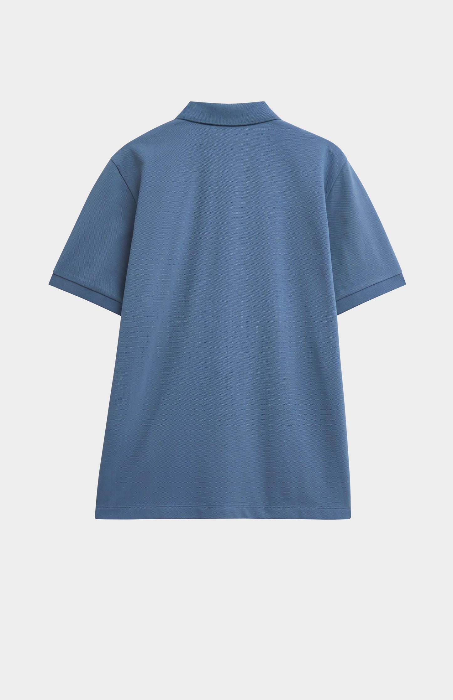 Blue polo shirt on a light gray background