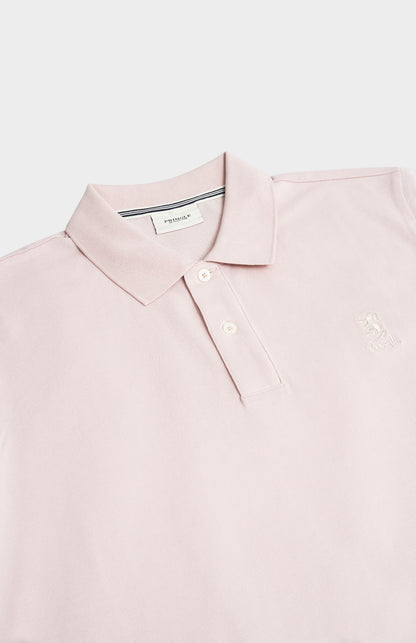 Pink polo shirt with a brand label on a light gray background