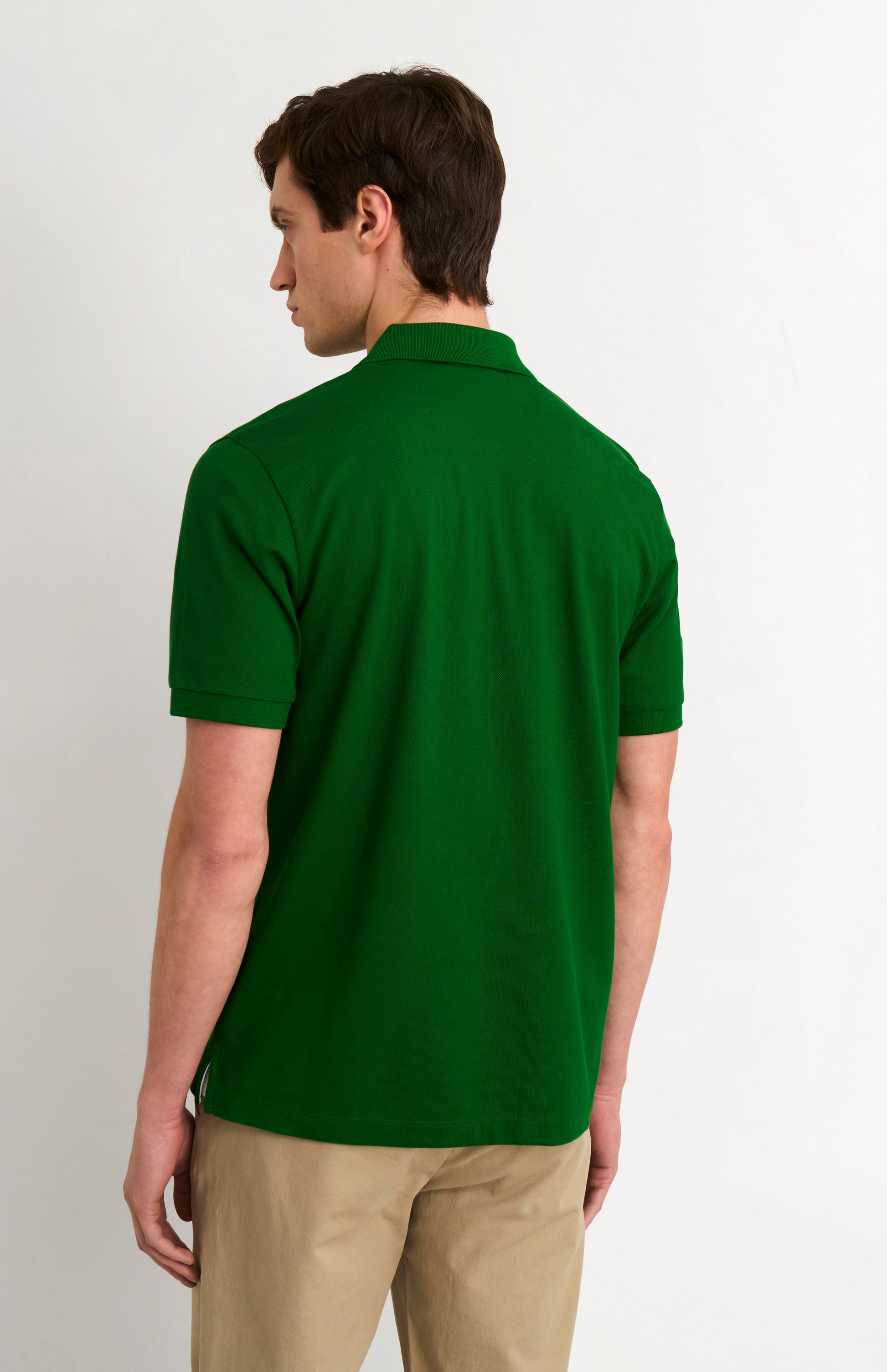 Man wearing a green polo shirt on a white background