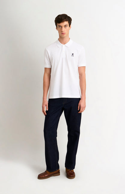 Man wearing a white polo shirt and dark pants on a white background