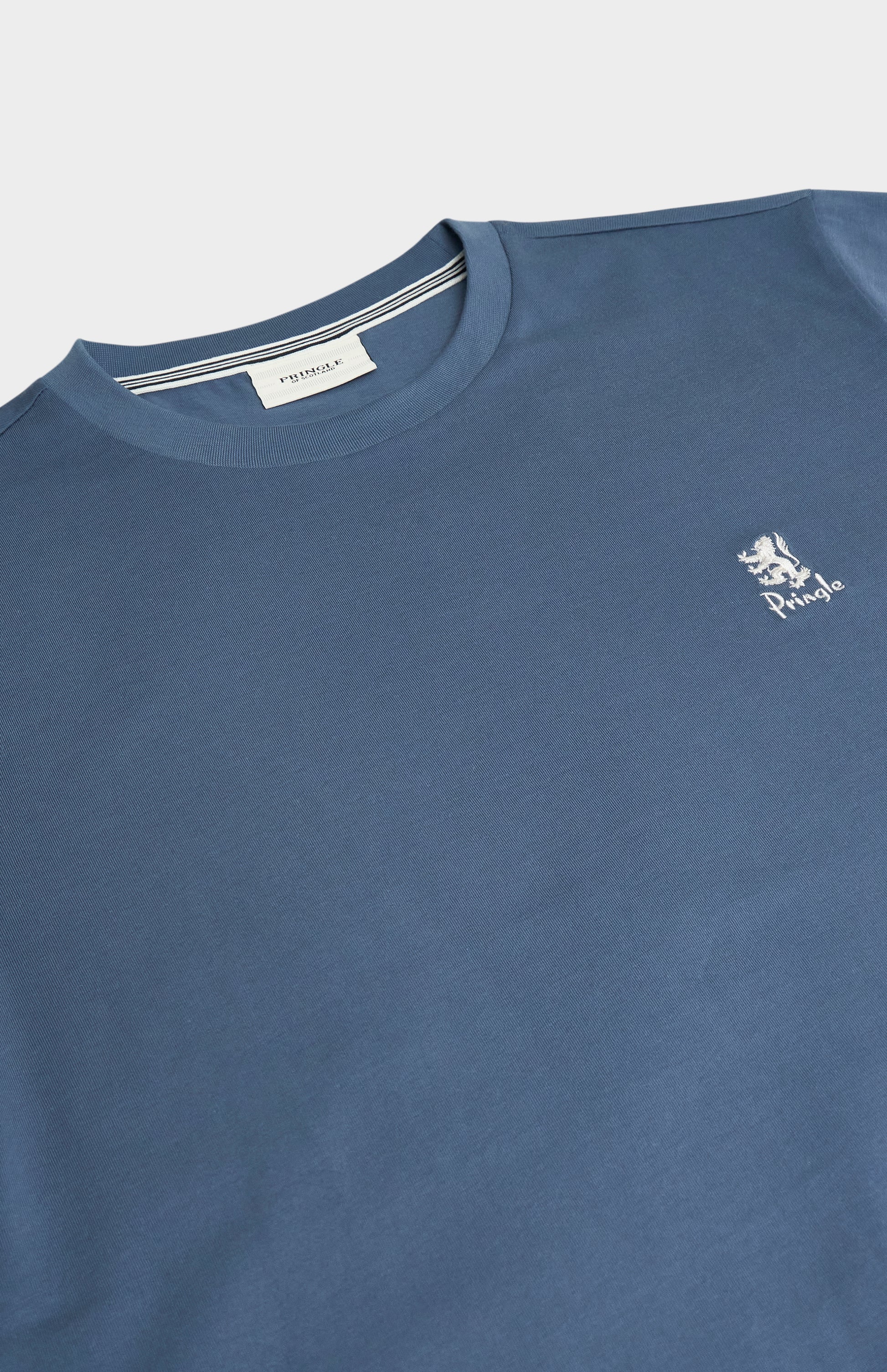 Blue t-shirt with a brand logo on a light gray background