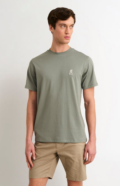 Man wearing a green t-shirt with a logo on a white background