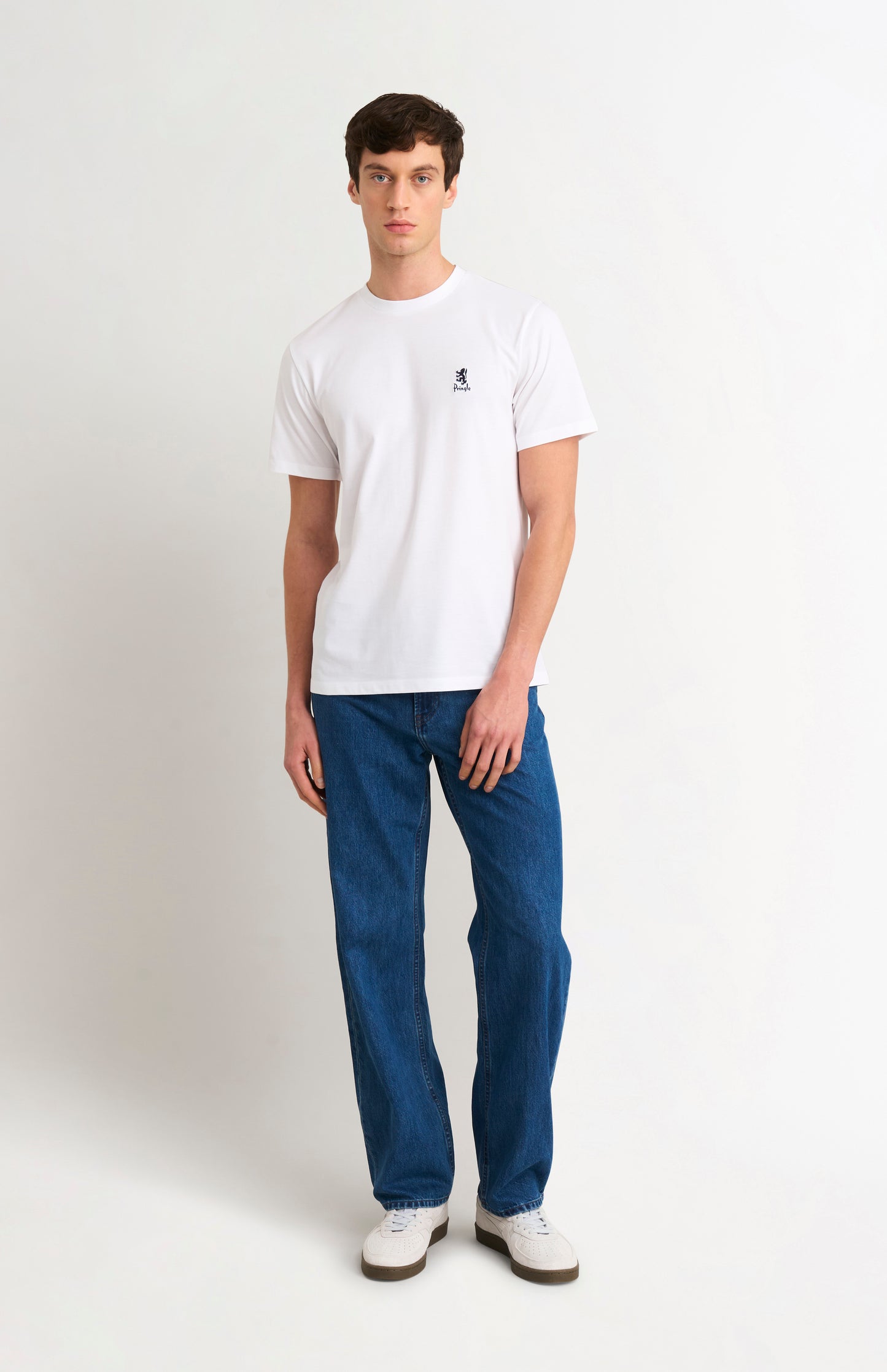 Man wearing white t-shirt and blue jeans on a white background