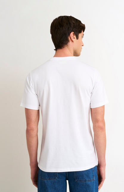 Man wearing a white t-shirt and blue jeans on a plain background