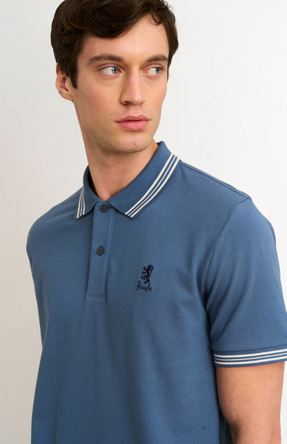 Man wearing a mid blue polo with tipping details and Pringle logo on upper side of chest
