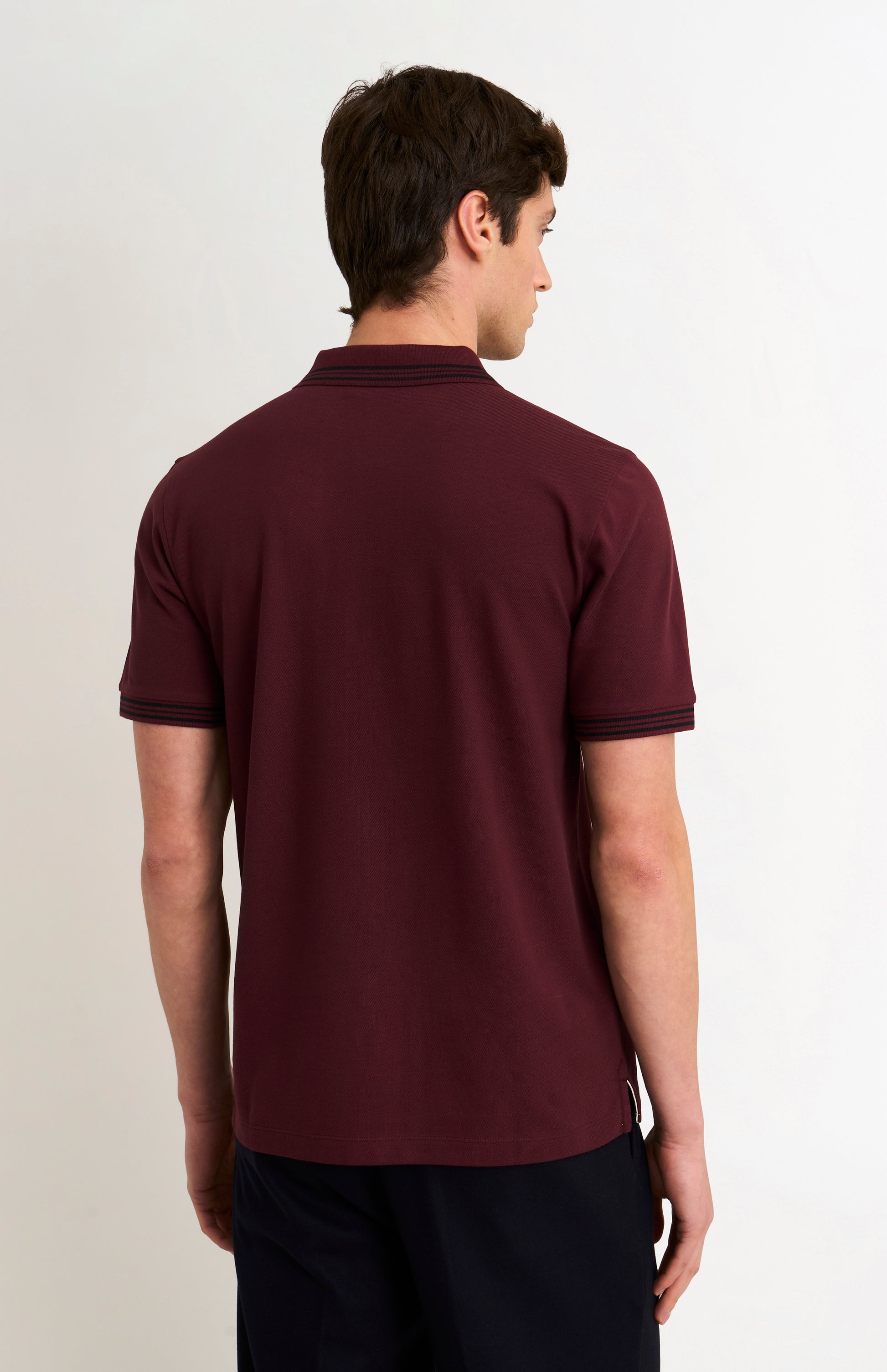 Back shot of a model wearing a burgundy polo with black tipping