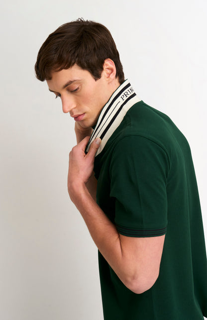 Detail shot of model wearing a forest green polo with tipping details and PRINGLE under flipped-up collar