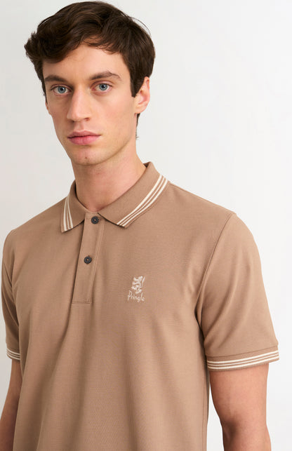 Close-up shot of model wearing a mushroom light brown polo with tipping and Pringle logo on upper side of chest