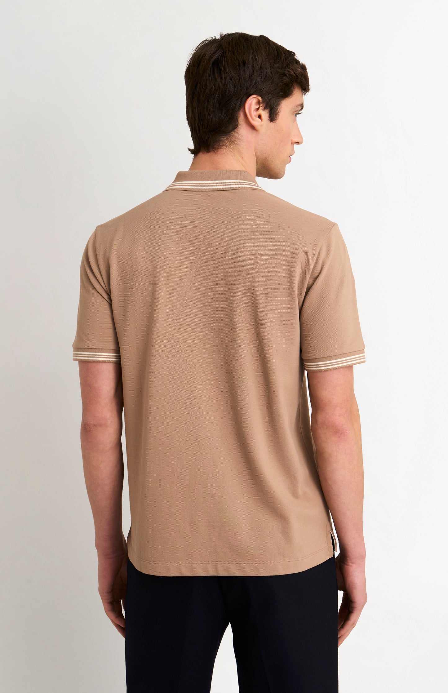Back shot of model wearing a mushroom light brown polo with tipping details