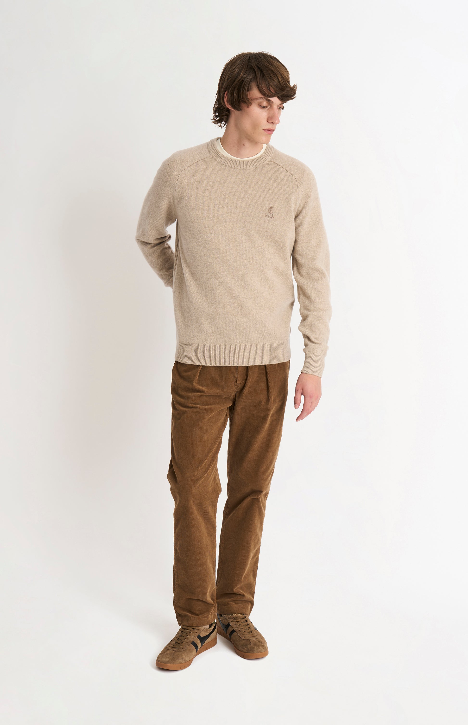 Pringle of Scotland Men’s Lambswool Crew Neck Jumper In Oatmeal on standing model from behind