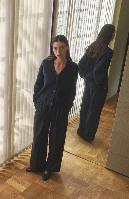 Woman wearing Pringle cashmere cardigan against a mirror