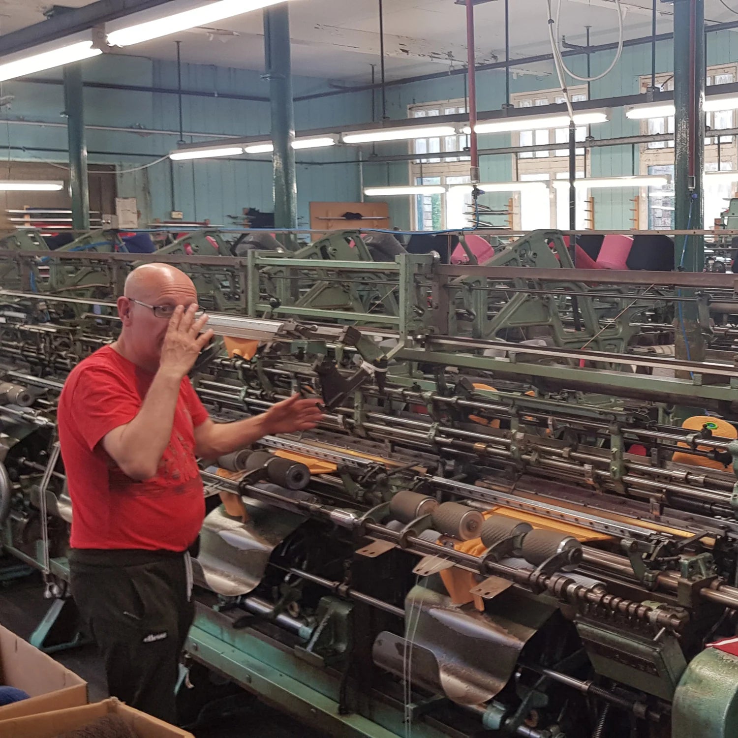 Pringle of Scotland worker operating large knitting machine 